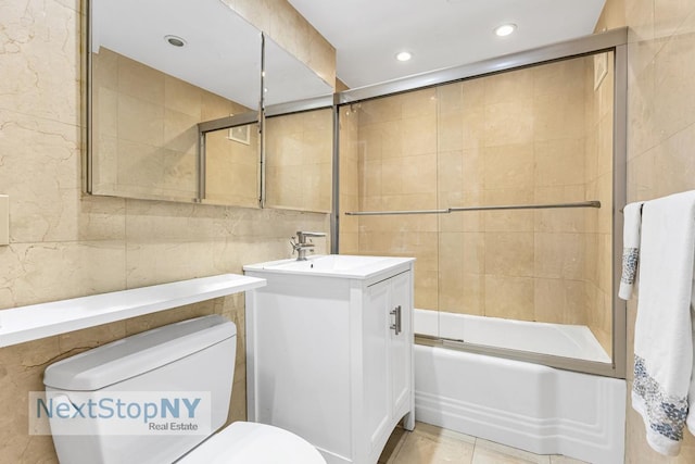 bathroom featuring tile walls, toilet, recessed lighting, vanity, and enclosed tub / shower combo