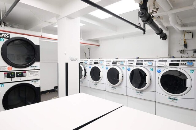 community laundry room with stacked washer / drying machine and washing machine and clothes dryer