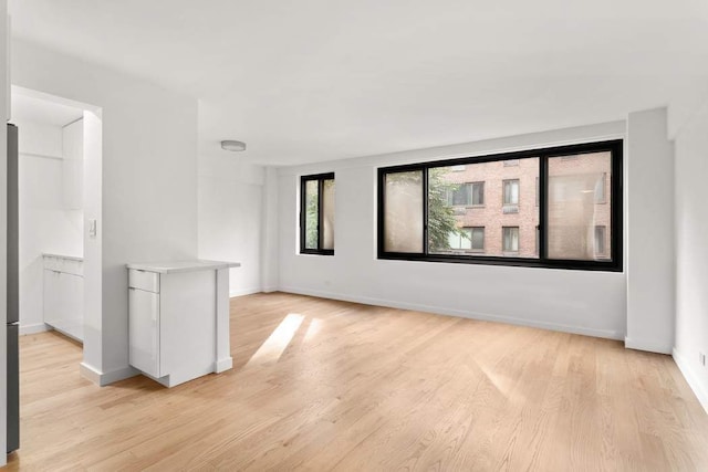 spare room with light wood-style floors and baseboards