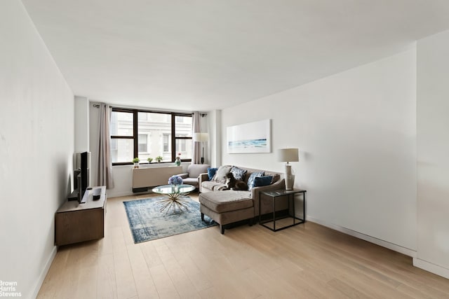 living area featuring light wood-type flooring and baseboards