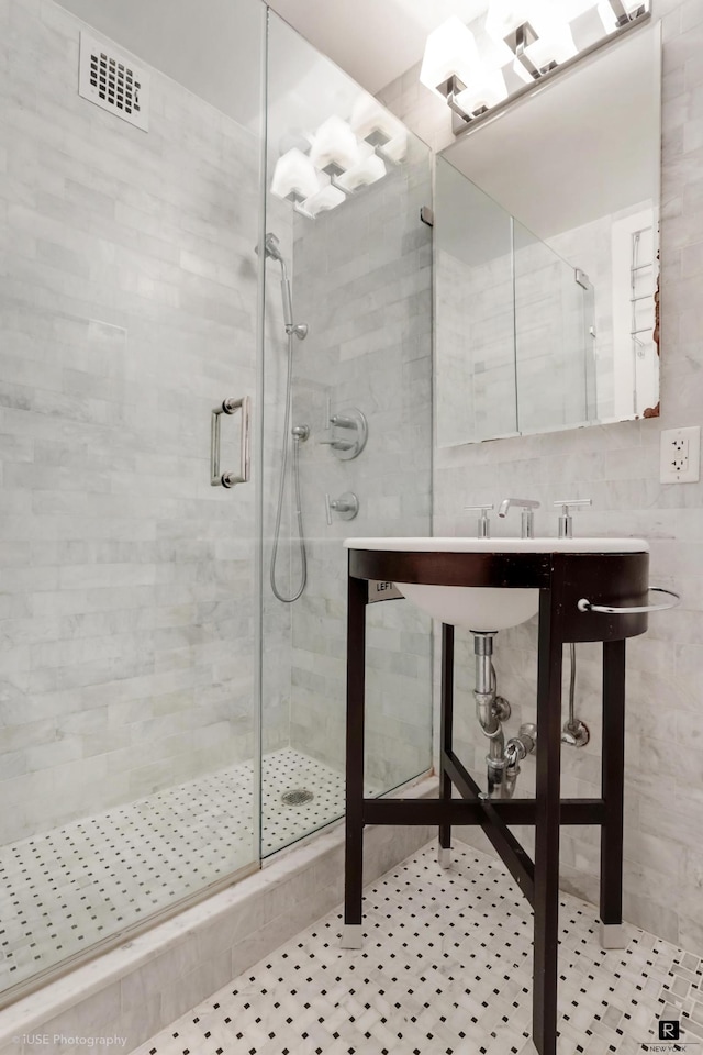 full bathroom featuring visible vents, tile walls, and a stall shower