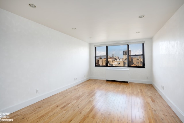 spare room featuring recessed lighting, baseboards, and hardwood / wood-style flooring