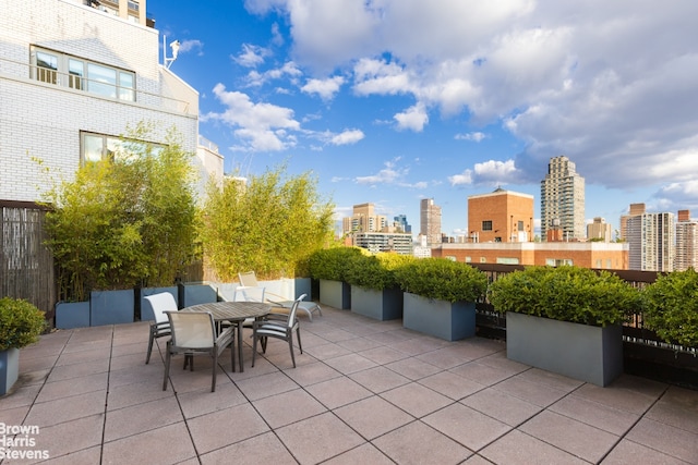 view of patio / terrace with outdoor dining space and a view of city