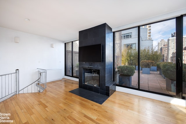 unfurnished living room with a fireplace, hardwood / wood-style flooring, and expansive windows