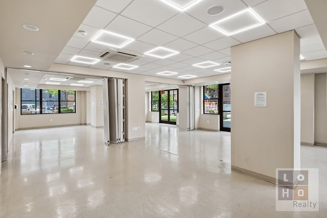 unfurnished room with visible vents, a paneled ceiling, and baseboards