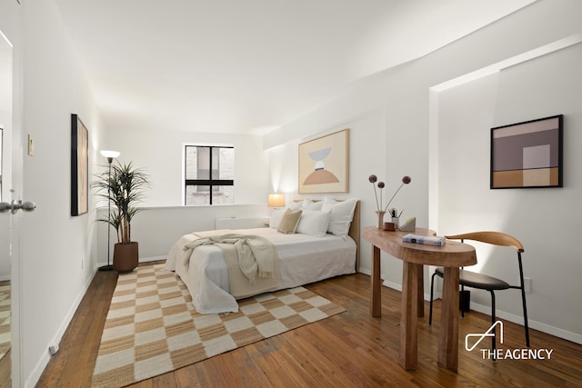 bedroom featuring baseboards and wood-type flooring