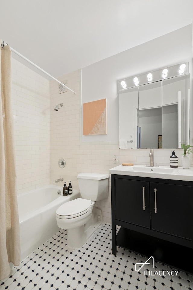 full bathroom featuring vanity, shower / bath combo with shower curtain, wainscoting, tile walls, and toilet