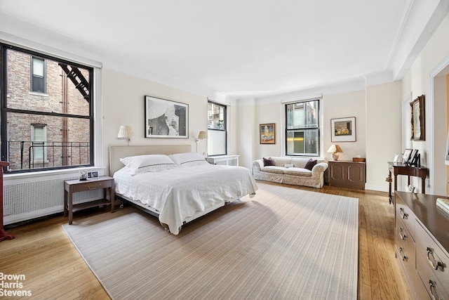 bedroom with light wood-style flooring and radiator heating unit