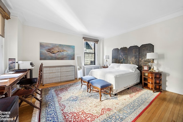 bedroom featuring crown molding, baseboards, and wood-type flooring