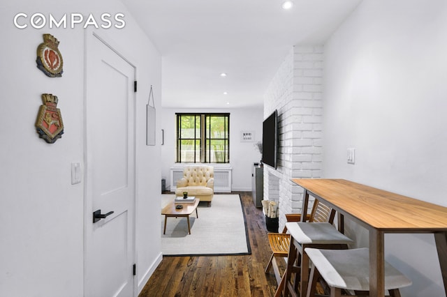 corridor featuring dark wood finished floors, recessed lighting, and baseboards