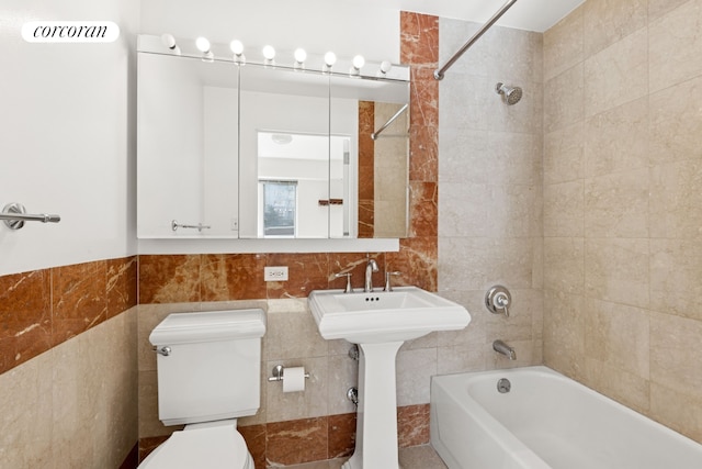 full bathroom featuring visible vents, bathing tub / shower combination, a sink, tile walls, and toilet