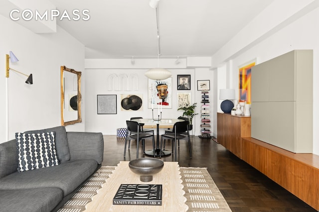 living room with dark wood-type flooring and rail lighting