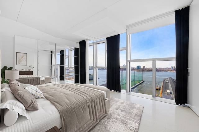 bedroom featuring a wall of windows and a water view