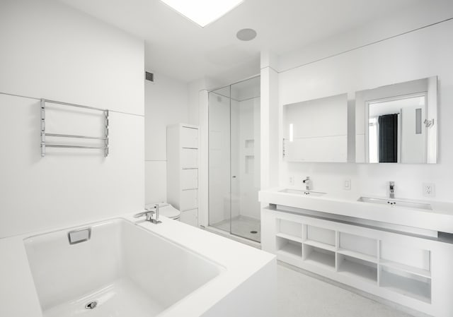 bathroom with double vanity, a bathtub, a stall shower, and a sink
