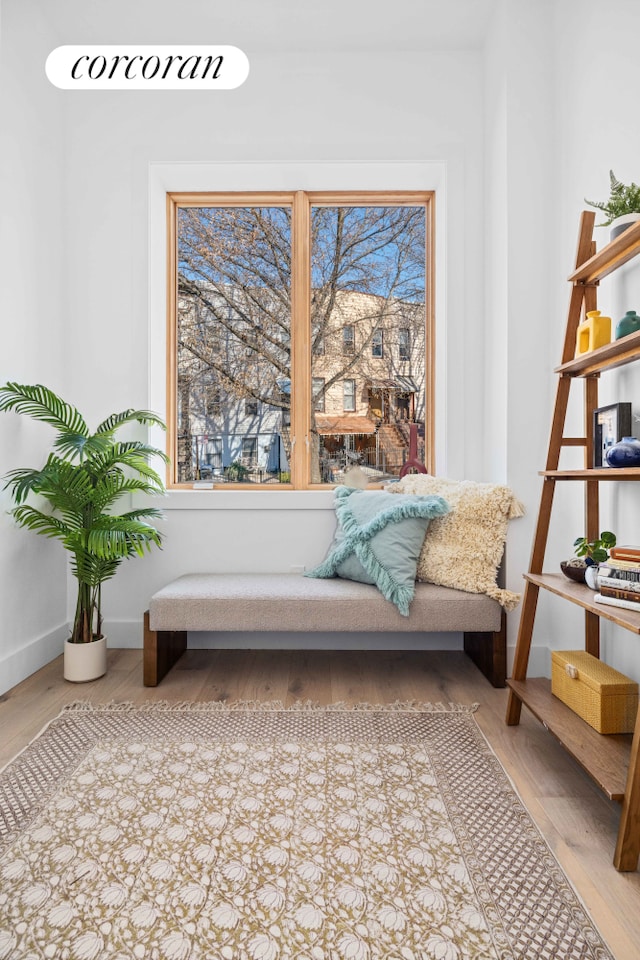 sitting room with baseboards and wood finished floors