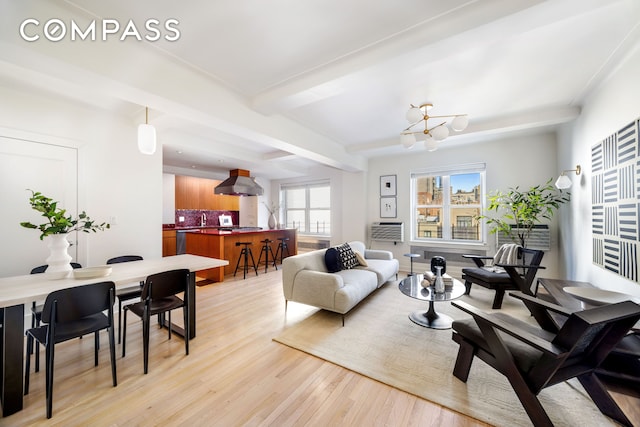living area with a chandelier, light wood-style flooring, and beamed ceiling