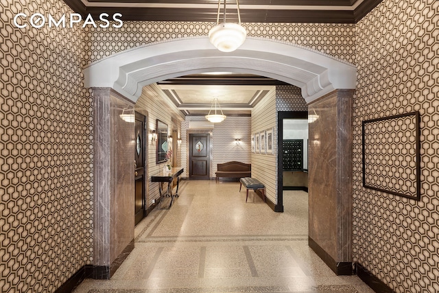 lobby with crown molding and wallpapered walls