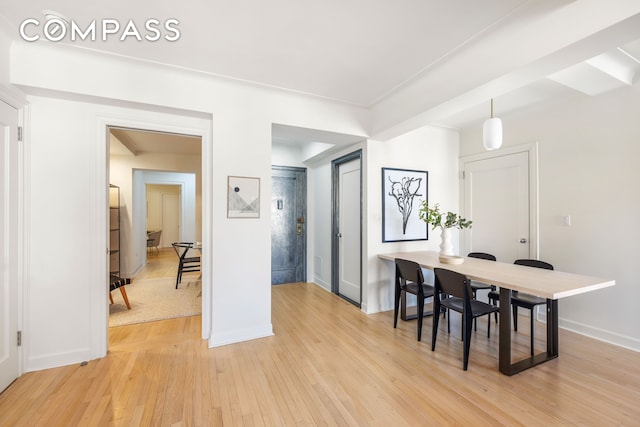 dining space with light wood finished floors and baseboards