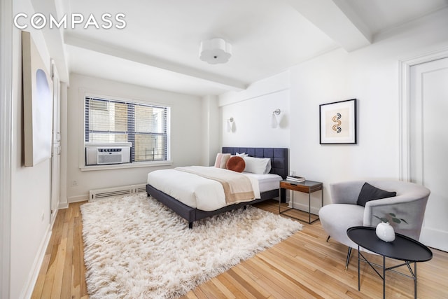 bedroom featuring cooling unit, wood-type flooring, beam ceiling, baseboards, and a baseboard radiator