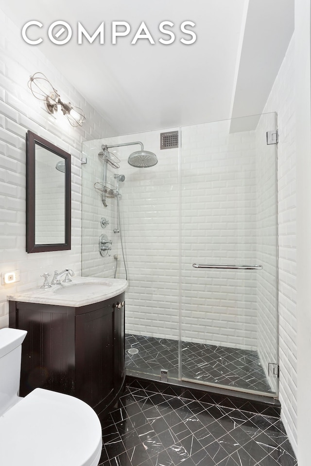 bathroom featuring toilet, a shower stall, vanity, and marble look tile flooring