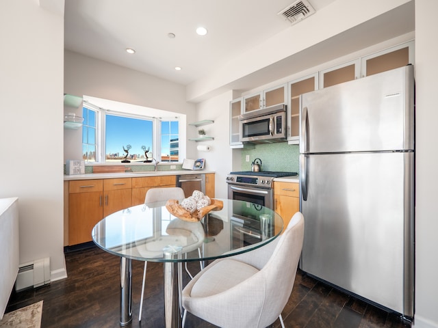 32-86 41st St Unit 5C, New York City, NY 11103 - kitchen with dark wood-style floors, stainless steel appliances, light countertops, visible vents, and decorative backsplash