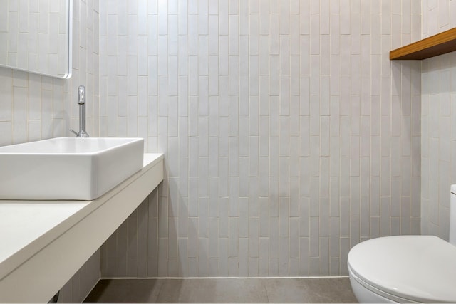 half bath featuring toilet, tile walls, and vanity