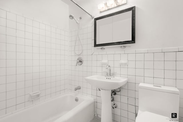 full bath with tile walls, toilet, and tub / shower combination