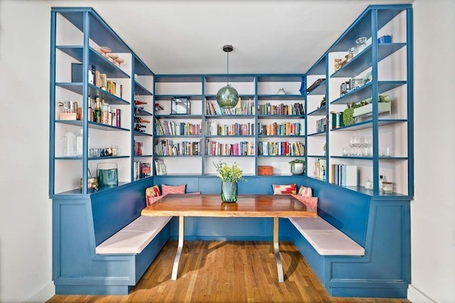 living area with built in shelves and wood finished floors