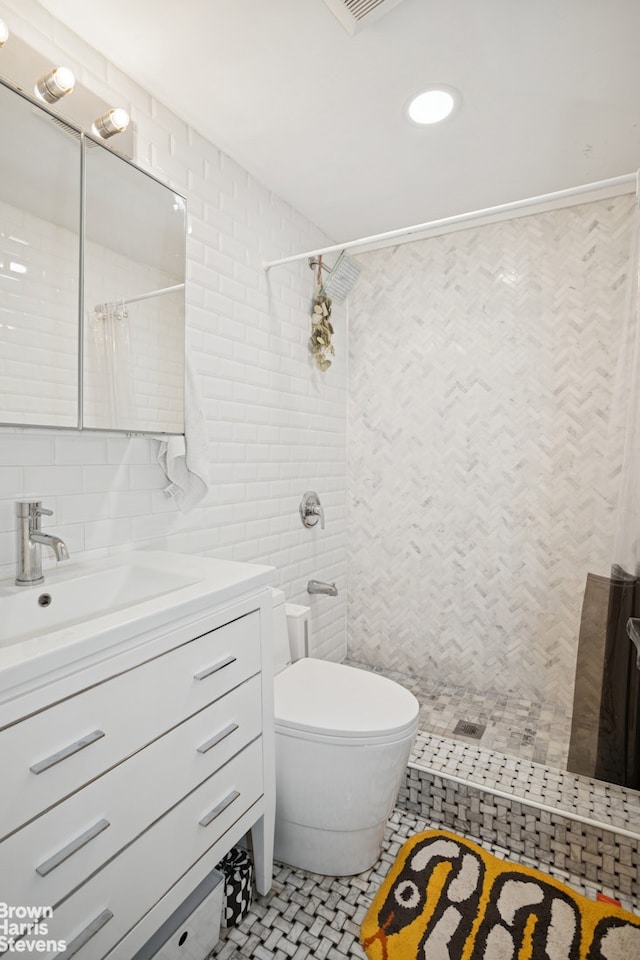 bathroom featuring vanity, tiled shower, tile walls, toilet, and backsplash