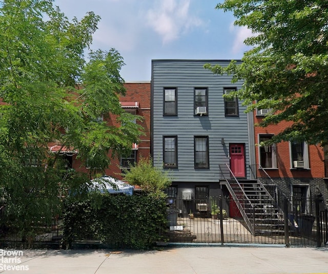 view of front of property with cooling unit and a fenced front yard