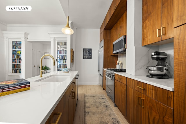 kitchen featuring visible vents, light wood finished floors, a sink, decorative backsplash, and premium appliances