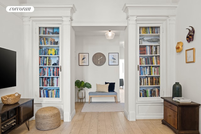 living area with hardwood / wood-style floors, decorative columns, visible vents, and built in features