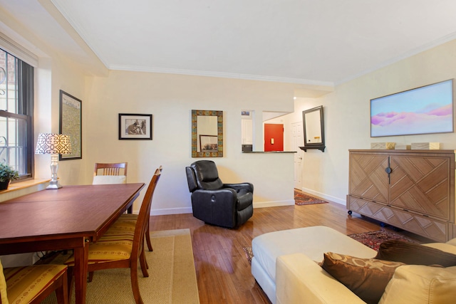 living room featuring crown molding, baseboards, and hardwood / wood-style flooring