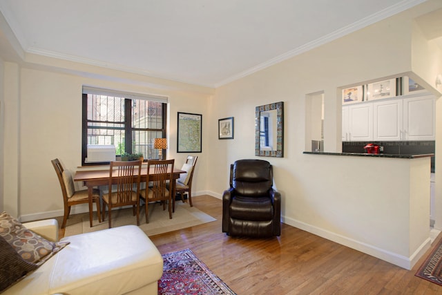 living room with crown molding, baseboards, and light wood-type flooring