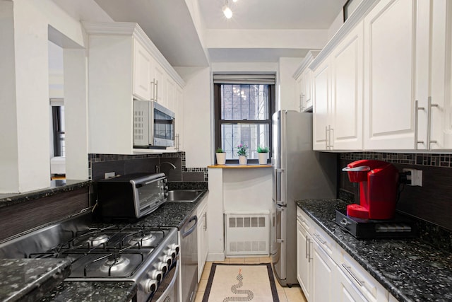 kitchen with visible vents, a sink, stainless steel appliances, white cabinets, and light tile patterned flooring