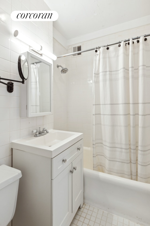 full bathroom with visible vents, tile walls, toilet, vanity, and shower / bathtub combination with curtain