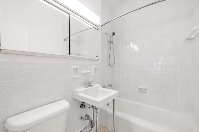 bathroom with toilet, tile walls, and bathtub / shower combination