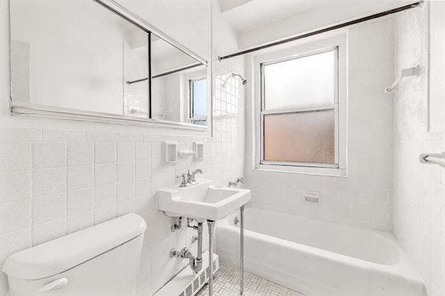 full bath featuring tile patterned flooring, toilet, tile walls, and a sink