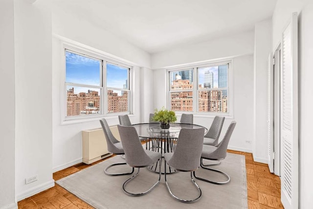 dining room with a city view and baseboards