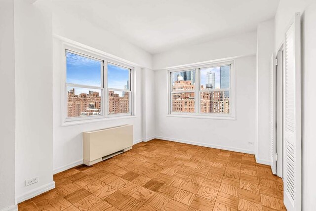 360 W 22nd St Unit 17E, New York City, NY 10011 - unfurnished room with radiator heating unit and baseboards