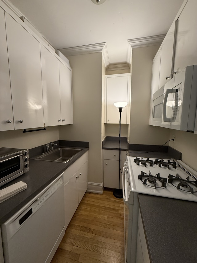 kitchen featuring wood finished floors, white appliances, white cabinetry, and a sink