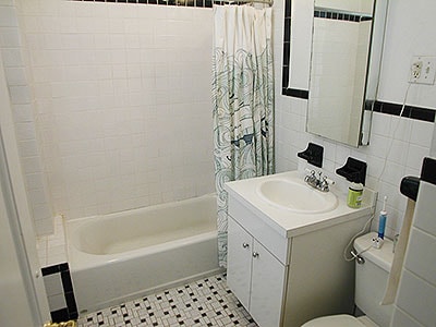 full bath with tile patterned flooring, toilet, vanity, shower / bath combo, and tile walls