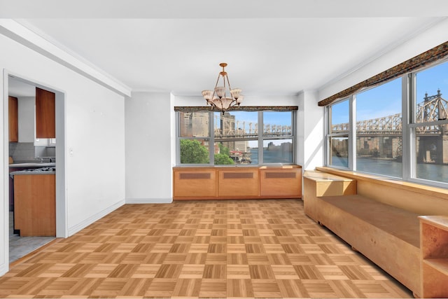 unfurnished sunroom with a notable chandelier and a water view