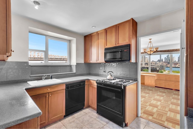 kitchen with a sink, decorative backsplash, plenty of natural light, and black appliances