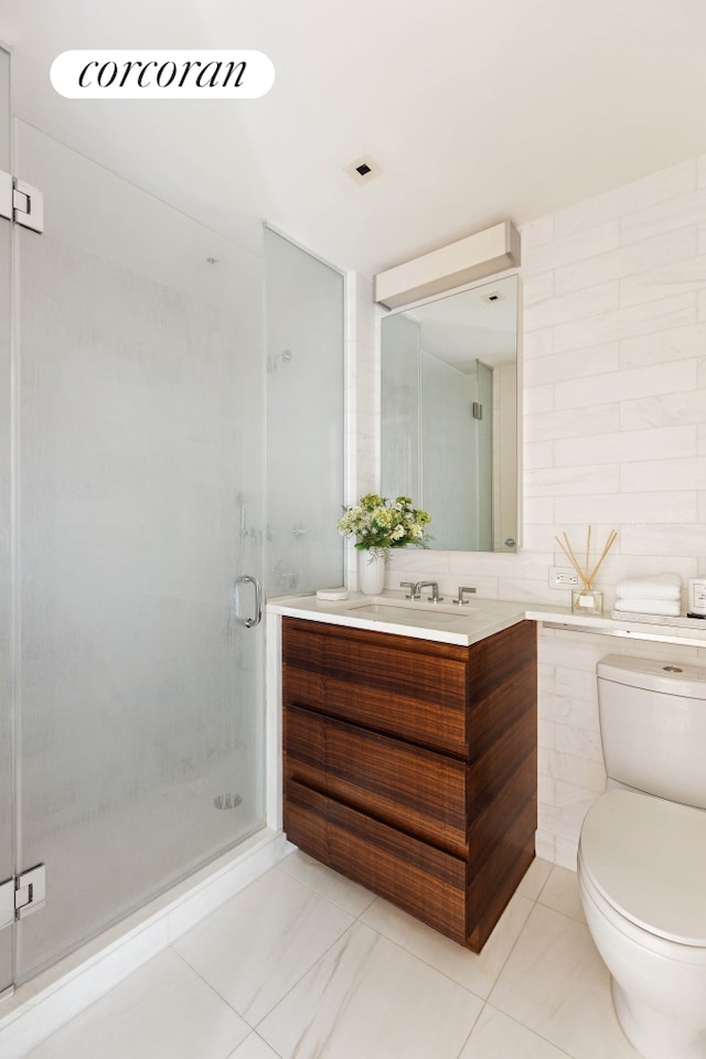 bathroom featuring toilet, vanity, a shower stall, and tile patterned flooring