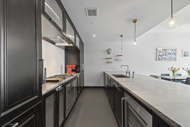 kitchen with visible vents, a sink, beverage cooler, stainless steel gas stovetop, and dark cabinets