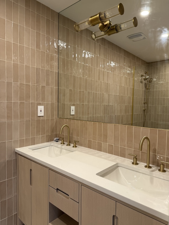 full bathroom with a sink, tile walls, and double vanity