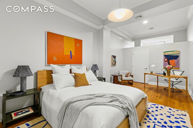 bedroom featuring visible vents, wood finished floors, and crown molding