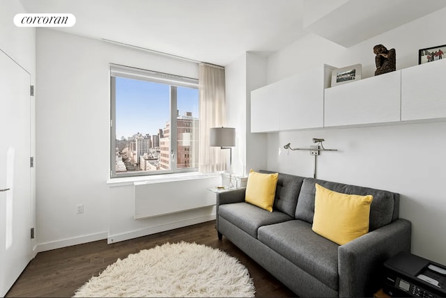 living area with dark wood finished floors, visible vents, a view of city, and baseboards