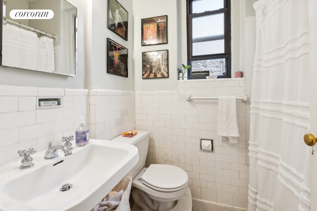 270 W 11th St Unit 4E, New York City, NY 10014 - full bathroom with tile walls, a sink, toilet, and a wainscoted wall